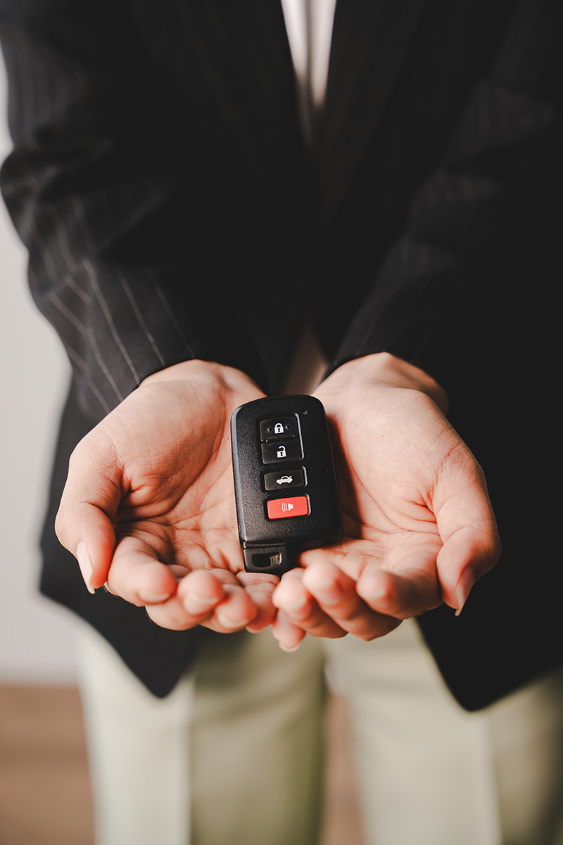 A car broker holds the car keys and prepares to deliver the car